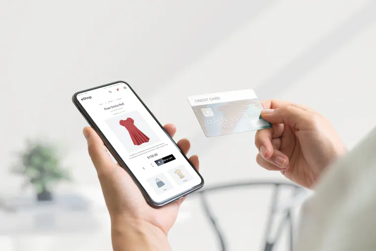 Online store displayed on a phone beside a payment card