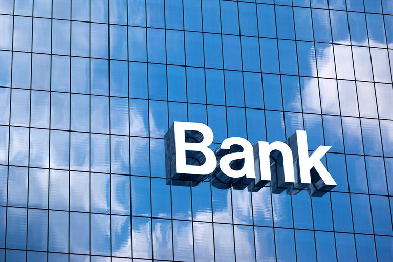 Bank sign mounted on the glass facade of a financial institution