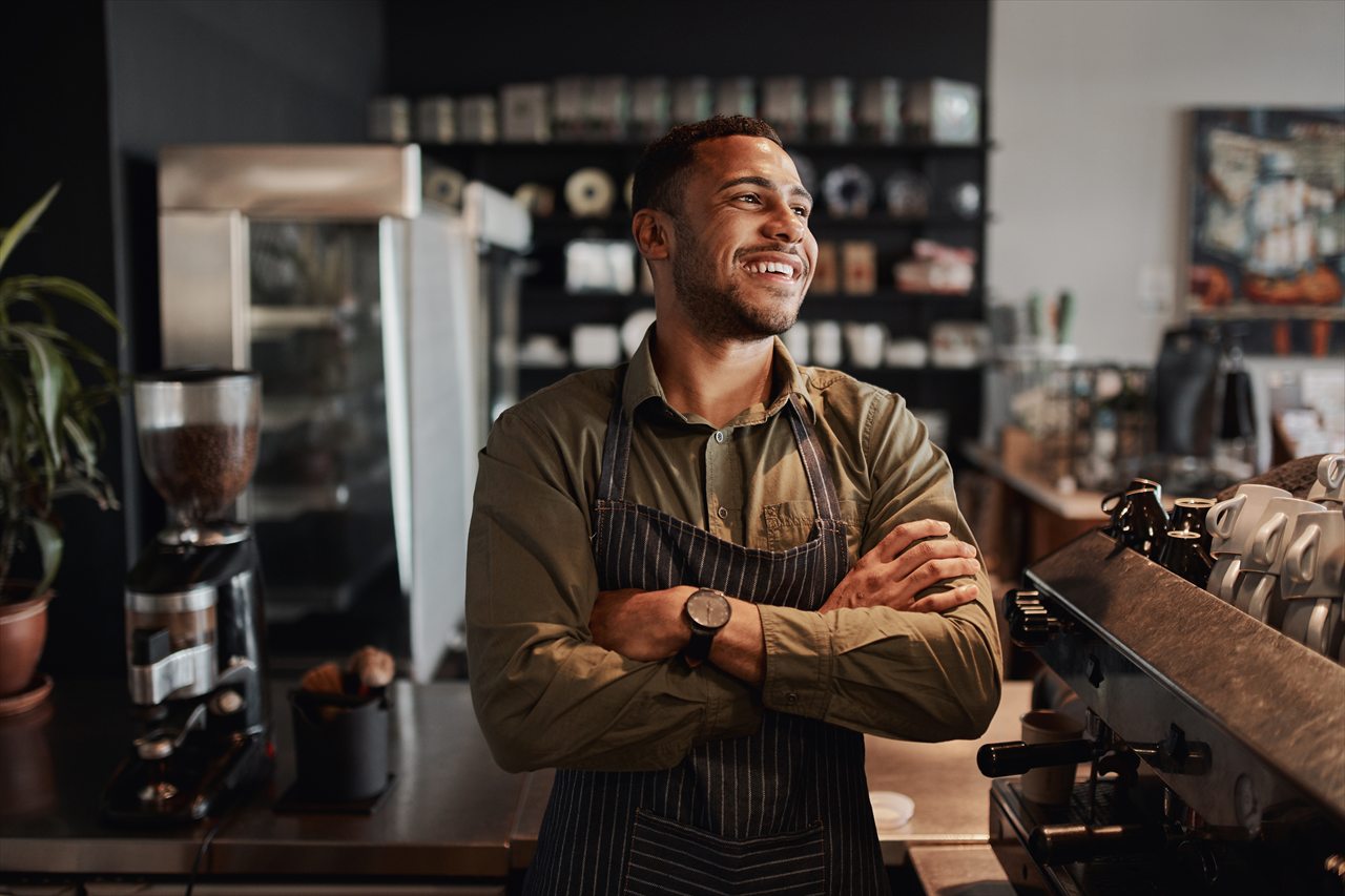 A small-business owner standing behind a café counter
