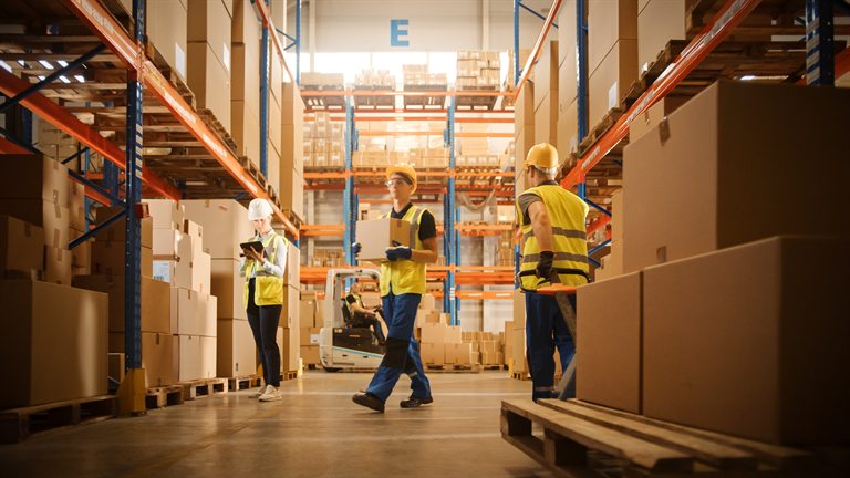 Distribution workers moving and checking boxes in a warehouse