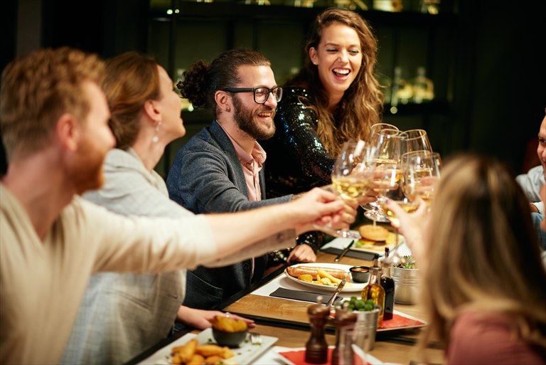 Guests raising wine glasses around a restaurant table