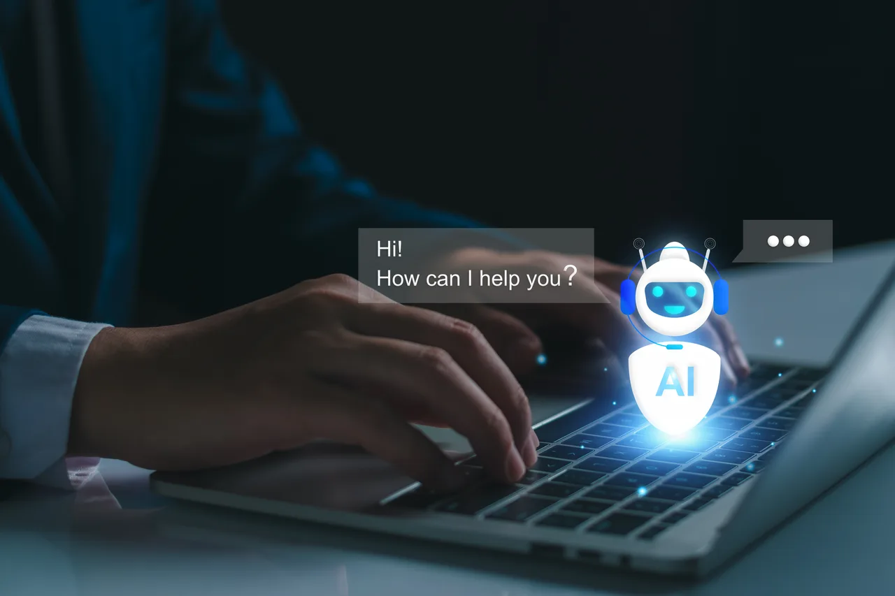 Hands typing on a laptop beside an illustrated AI chatbot and message bubbles